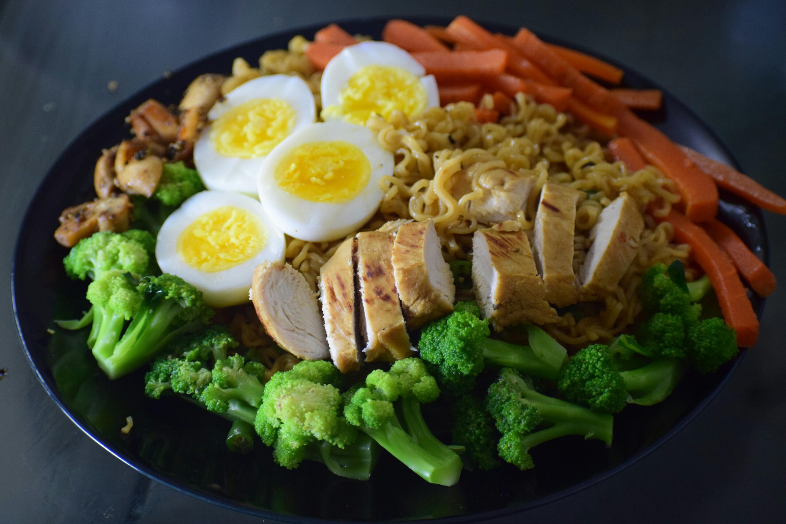 Delicious noodle dish with chicken, broccoli, eggs, and carrots, perfect for a healthy meal.